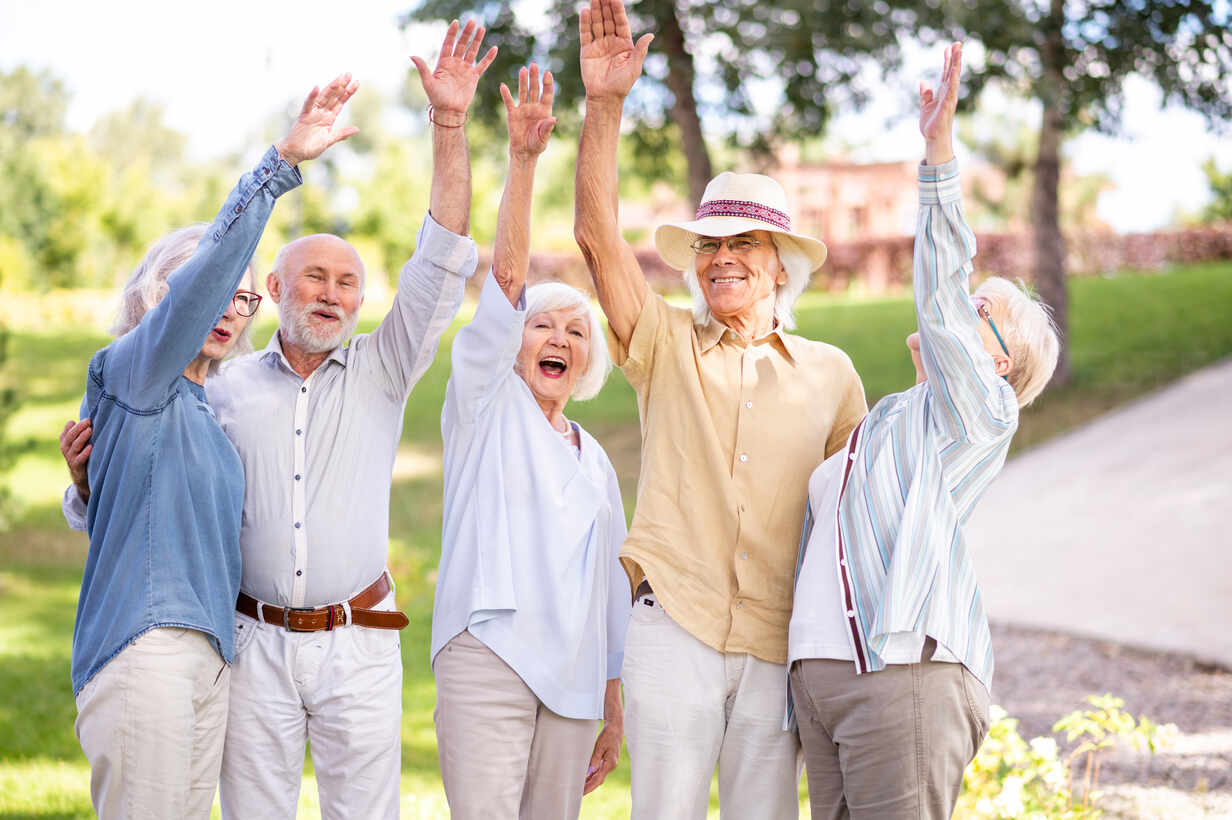 Group of happy elderly people bonding outdoors at the park - Old people in the age of 60, 70, 80 having fun and spending time together, concepts about elderly, seniority and wellness aging